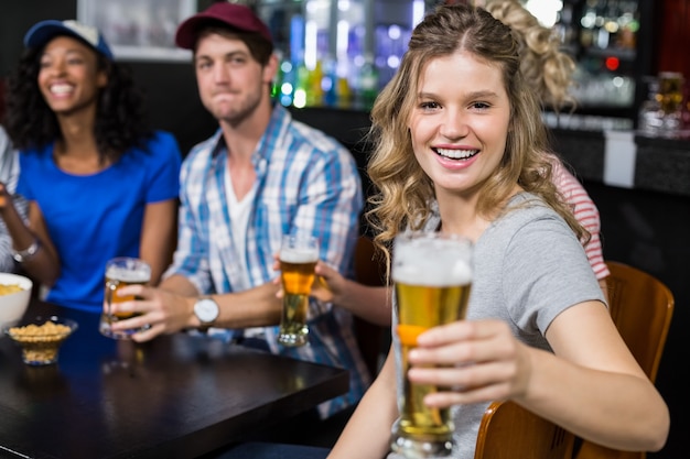 Smiling blonde woman offering beer