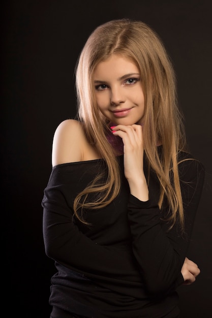 Smiling  blonde woman with  perfect makeup posing in the shadows