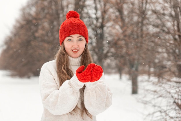 Smiling blueeyed woman looks straight into camera outdoor Portrait of happy girl walking in winter park