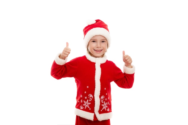 A smiling boy dressed as Santa Claus holds his thumbs up