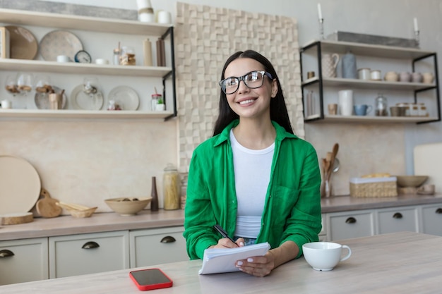 Smiling brunette standing and looking at camera in the home office