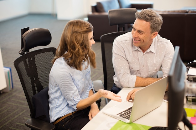 Smiling business colleagues discussing while working together