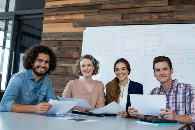 Smiling business executives sitting in office with document