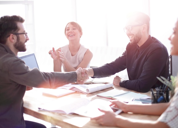 Smiling business partners shaking hands at a business meeting