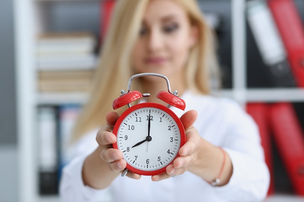 Photo smiling business woman holding in hand clock