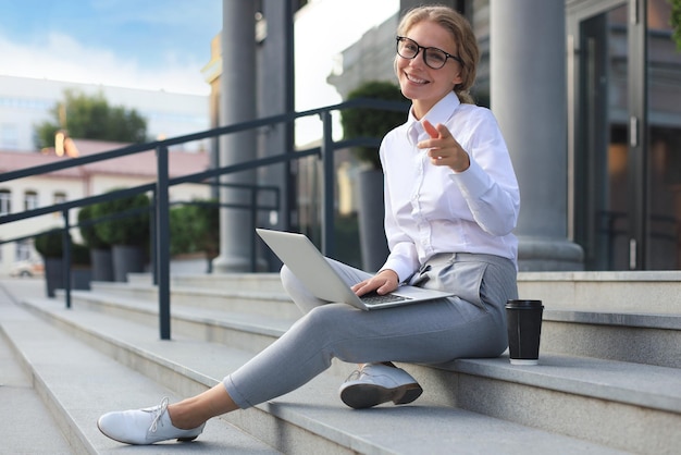 Smiling business woman pointing her finger to you