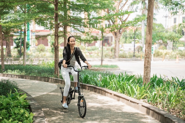 Smiling business woman riding her folding bike