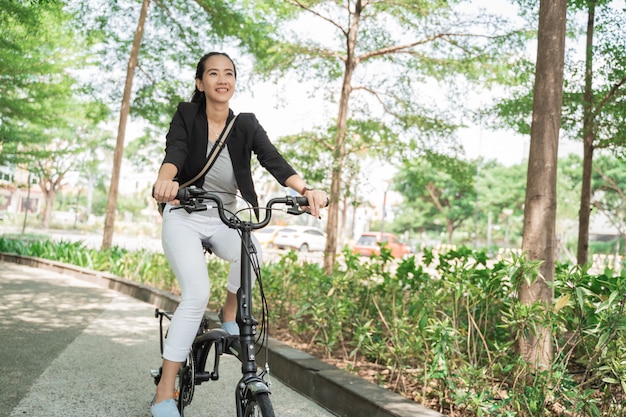 Smiling business woman riding her folding bike