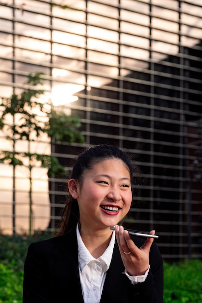 Smiling business woman talking by phone outdoors