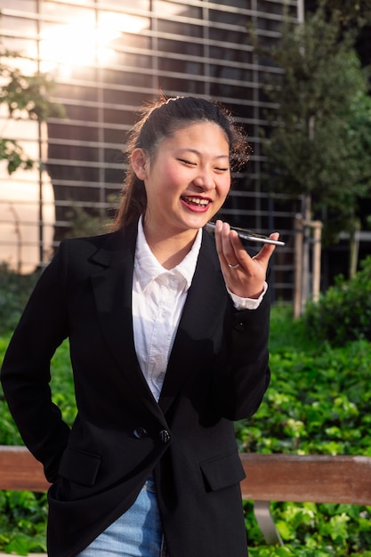 Smiling business woman talking by phone in a park