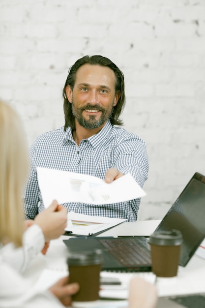 Smiling Businessman passes the paper form to his colleague