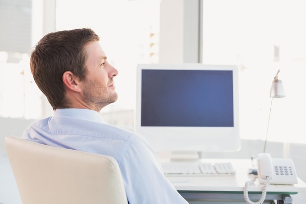 Smiling businessman sitting at his desk 