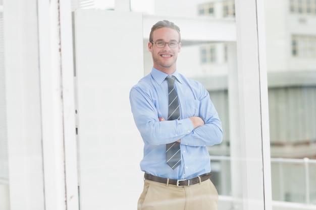 Smiling businessman standing with arms crossed