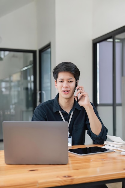 Smiling businessman talking on phone sitting at desk with laptop friendly manager consulting customer by phone happy man chatting with friends from work