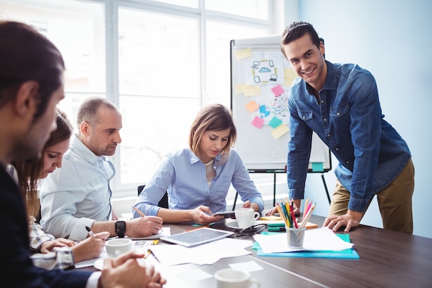 Smiling businessman with coworkers in meeting room