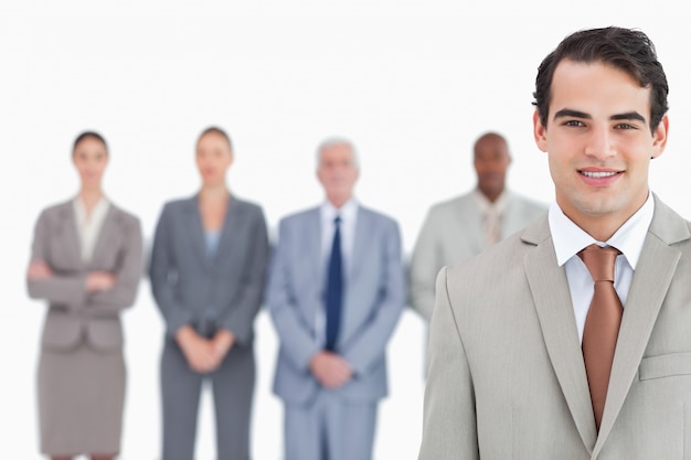 Smiling businessman with his team behind him