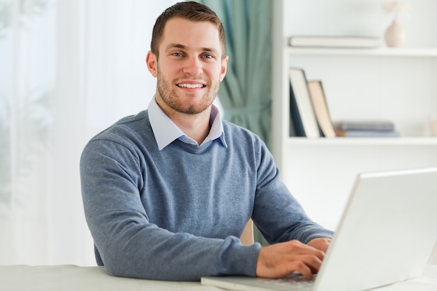 Smiling businessman with laptop in his homeoffice