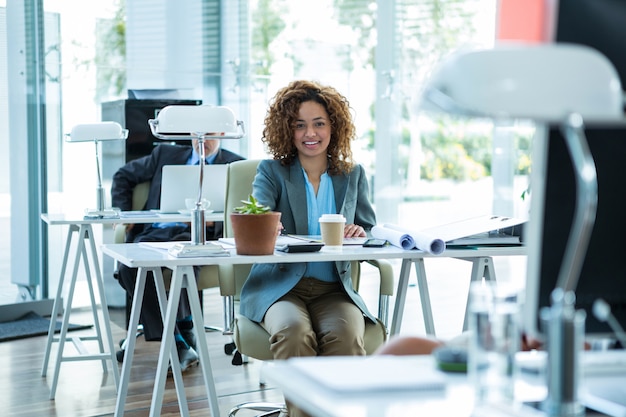 Smiling businesswoman sitting on chair at office