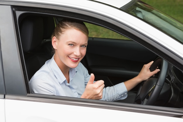 Smiling businesswoman sitting in drivers seat 