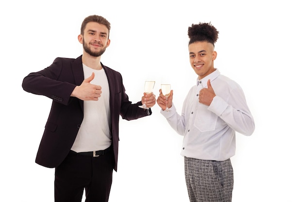 Smiling Caucasian and American men standing next to each other drinking champagne from glasses