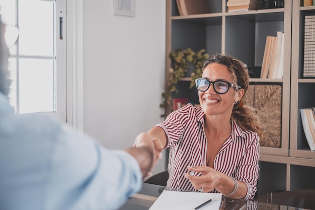 Smiling caucasian female hr manager handshake hire male candidate at job interview make good first impression happy mixed race client shake hand of bank broker respect business agreement conceptxA