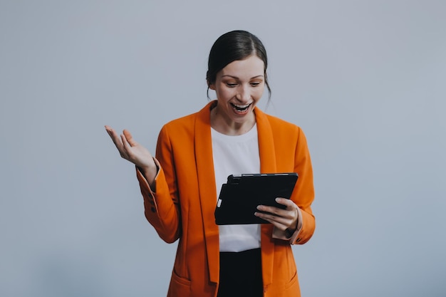 Smiling caucasian young woman girl freelancer student using digital tablet having idea pointing upwards on copyspace surfing on social media mobile applications elearning isolated in white