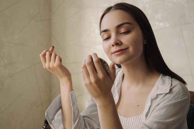 Smiling charming woman with lip makeup and lipstick looking in pocket mirror