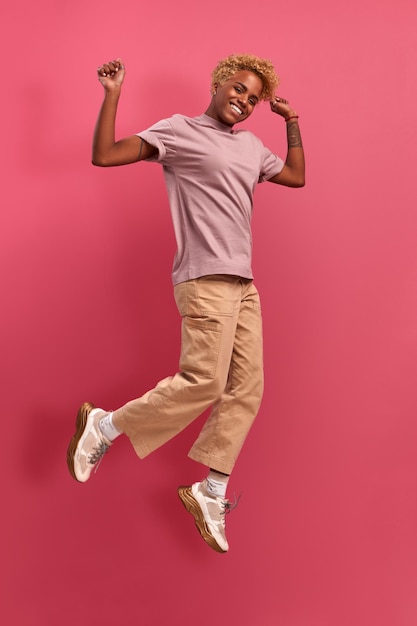 Smiling and cheerful positive african-american girl in casual clothes rejoices