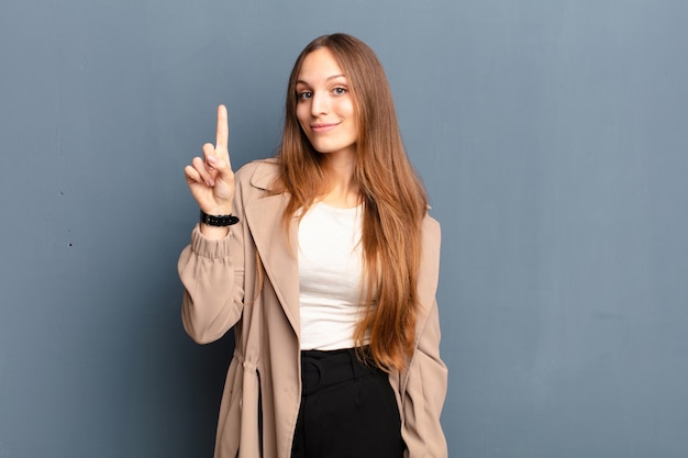 smiling cheerfully and happily, pointing upwards with one hand