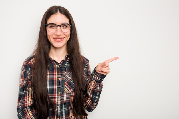 Smiling cheerfully pointing with forefinger away