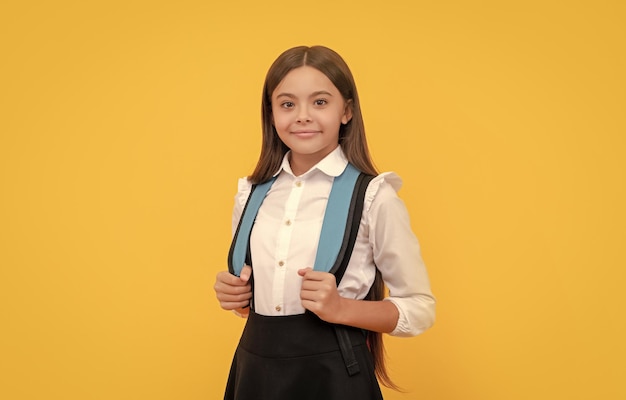 Smiling child in school uniform carry school bag education