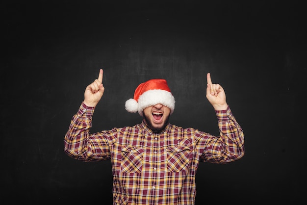 Smiling christmas man wearing a santa hat isolated on black