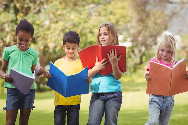 Smiling classmates reading in notepads 