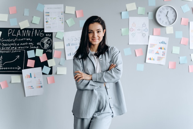 Smiling, confident beautiful brunette on the background of the office