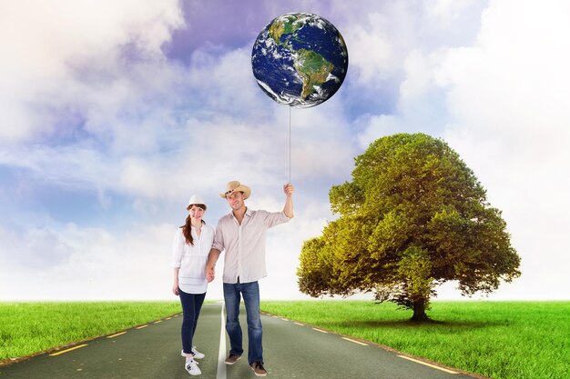 Photo smiling couple both wearing hats against road leading out to the horizon