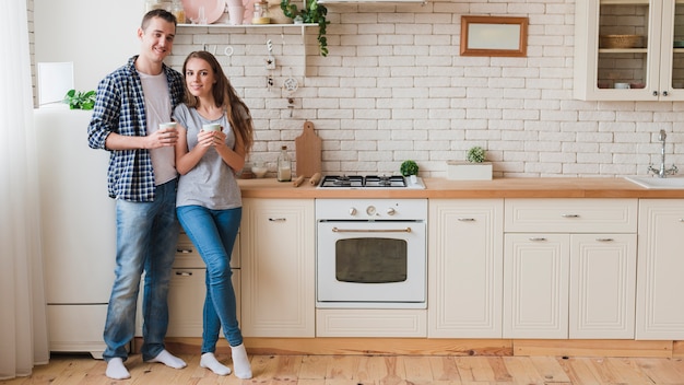 Smiling couple in love standing in kitchen