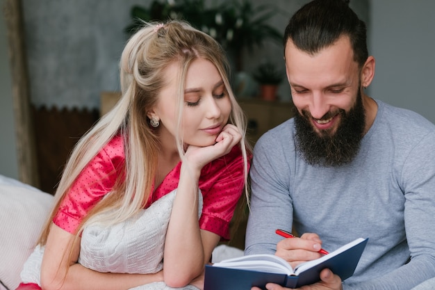 Smiling couple making notes on notebook