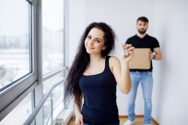 Smiling couple unpack boxes in new home.