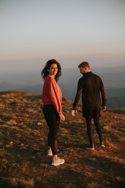 Smiling couple walking over green hills