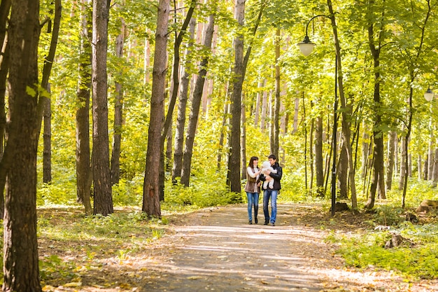 Smiling couple with baby in autumn park