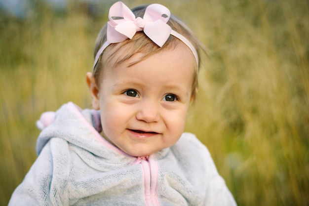 Photo smiling cute baby girl wearing hairband looking away