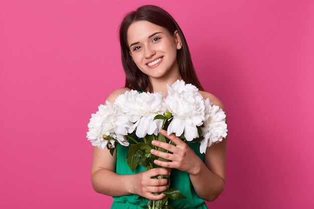 Smiling cute female posing isolated over pink