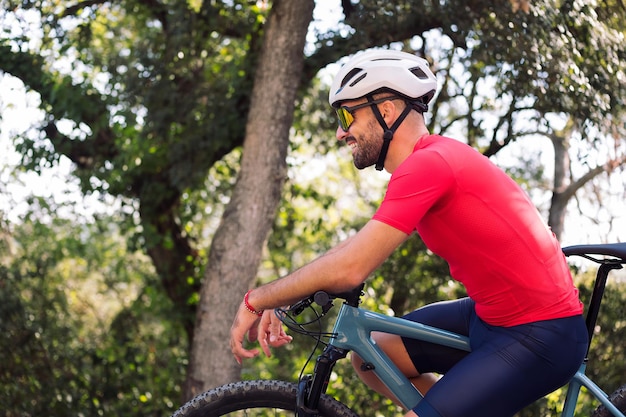 Smiling cyclist resting on his bike after training