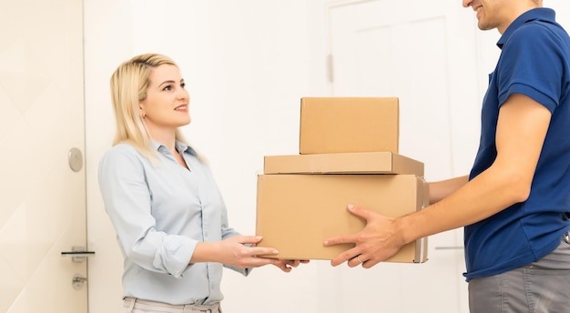 Smiling delivery man giving boxes to woman customer at home for online shopping service concept