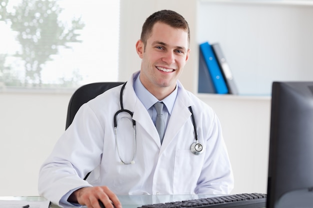 Smiling doctor on his computer