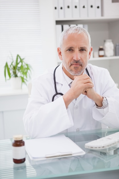 Smiling doctor sitting at his desk