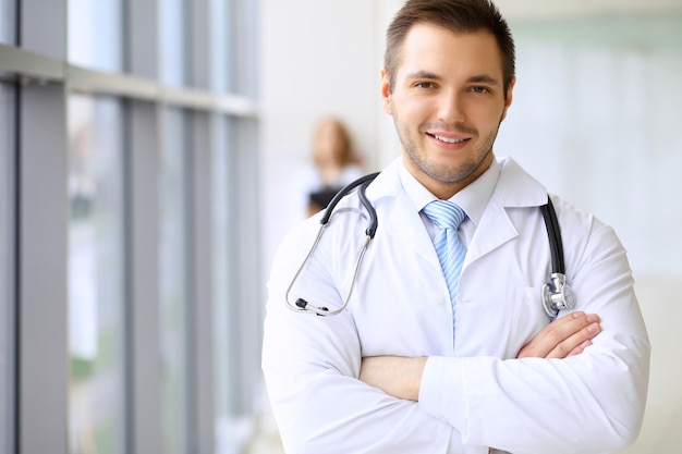 Smiling doctor waiting for his team while standing upright