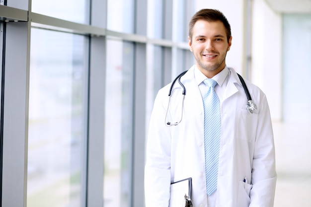 Smiling doctor waiting for his team while standing upright