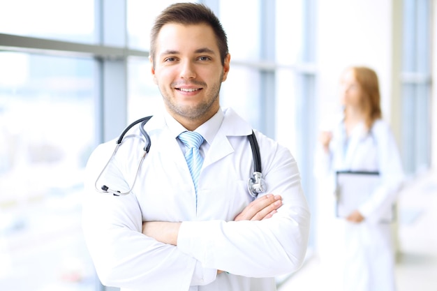 Smiling doctor waiting for his team while standing upright