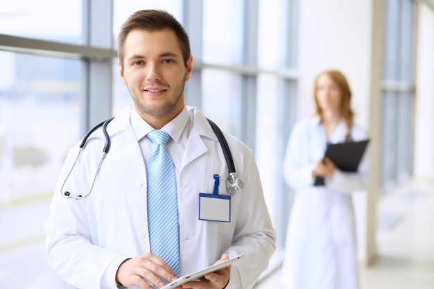 Smiling doctor waiting for his team while standing upright